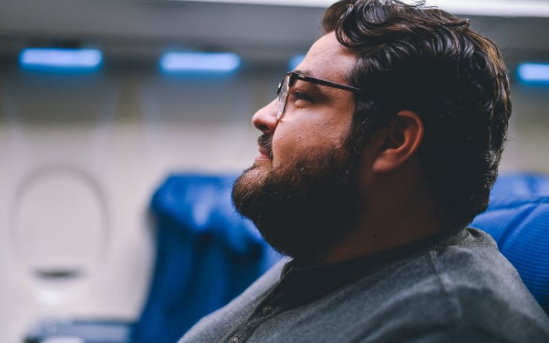 Image from gallery: Hispanic man of a larger body size on an airplane